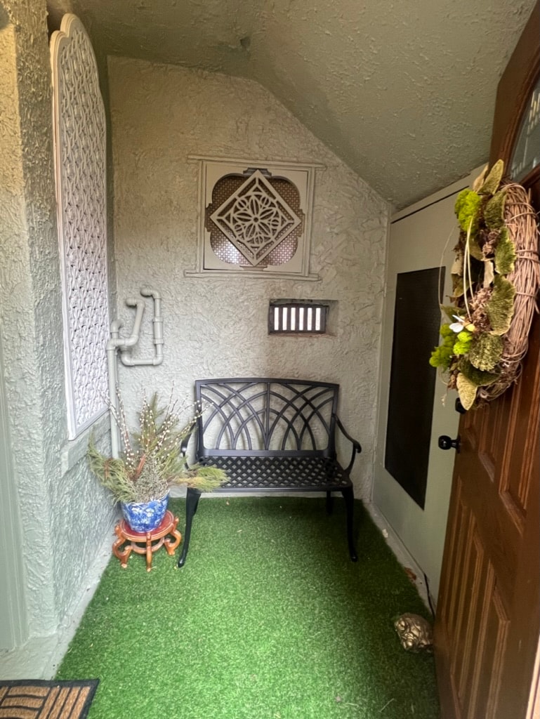 Decorated front porch with iron bench and wreath